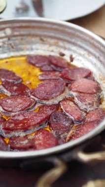 Tahta bir masada tavada kahvaltı sosisi pişirmek.,