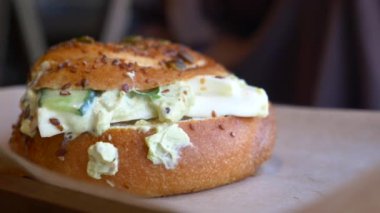 Peynirli ve taze sebzeli leziz simit sandviçi, gurme ısırığı için mükemmel.