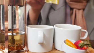 Kadın eli yeşil çay fincanına limon koyuyor. .