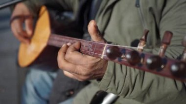  Erkekler geleneksel müzik enstrümanı Türkçe saz çalıyor .