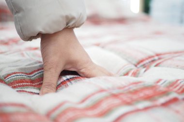 Yatağın üzerine elinle ortopedik yatak dokundur ve bastır.