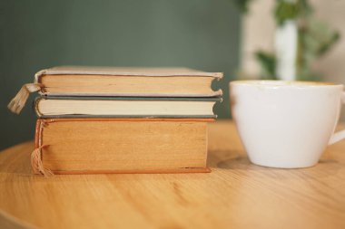 Antika kitap, ahşap masada kahve fincanı okumak ve rahatlamak için rahat bir atmosfer..