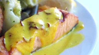  Tabakta taze sebzelerle servis edilen ızgara somon. .