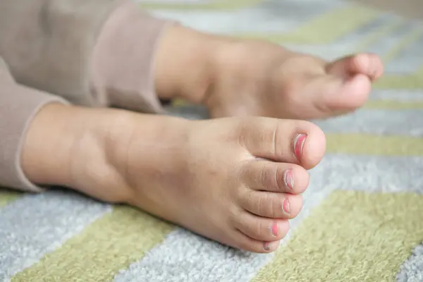 stock image A childs bare feet on a wooden floor, representing innocence and playtime at home