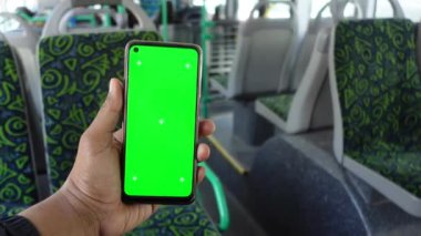 Yolcu otobüste telefonuyla oturuyor.