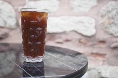 Şık ve modern yuvarlak bir masada servis edilen ferahlatıcı bir buzlu içecek.