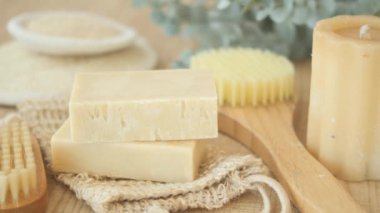 Tahta bir yüzey üzerinde sabun, vücut fırçası, lif ve okaliptüs içeren doğal spa seti..