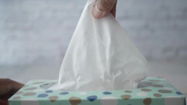 Kağıt mendil kutusundan bir parça mendil çıkar. ,