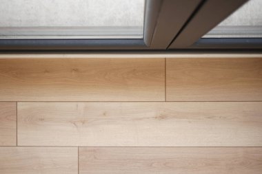 Şık ahşap döşeme modern bir sofistike ortamda cam kapılarla buluşuyor.