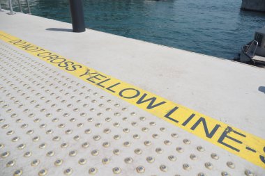 Lütfen limanda görülen güvenlik uyarısına dikkat edin. Sarı çizgiyi asla geçmeyin.