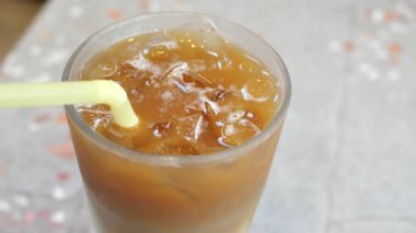 Kafe masasında şeffaf bir bardakta buzlar eridi. ,