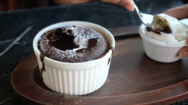 Çikolatalı lava kekinin tadını çıkar, üzerine pudra şekeri serp ve yanında krem şanti ile servis et.