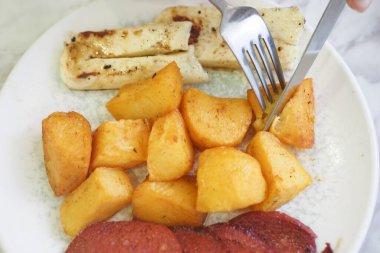 Lezzetli bir patates kızartması, ızgara muz ve tüm damak tadını veren dilimlenmiş et karışımı.