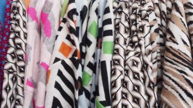 Değişik desenler ve renkler sergilenen canlı bir kumaş koleksiyonu.