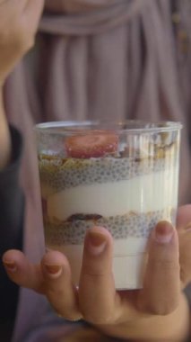 Granola ve taze çilek katmanlı besleyici chia tohumu pudingi, sağlıklı bir atıştırmalık için mükemmel..