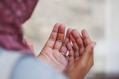 Başörtülü Müslüman genç kadın camide dua ediyor