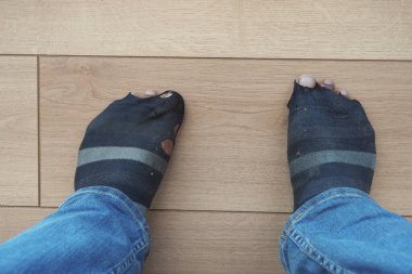 Kanepede otururken kirli çoraplı erkekler .