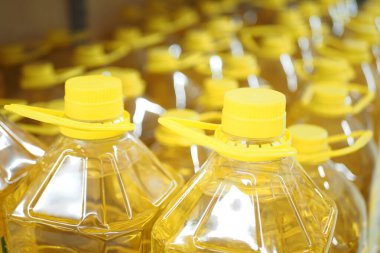 Sarı ayçiçeği yağı şişesi bir mağazada dizilmiş. .