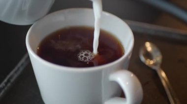 Sütü çayla bardağa dolduruyorum.