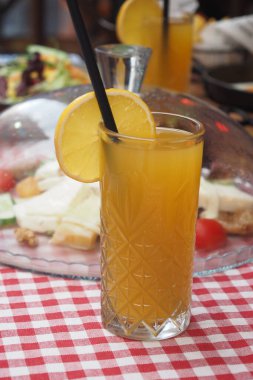 Bir dilim limonla süslenmiş canlı ve ferahlatıcı bir portakal suyu.