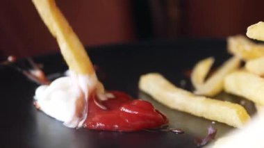 Kremalı sosa batırılmış çıtır patates kızartması yakın plan, mükemmel konforlu yemek anını yakalıyor..