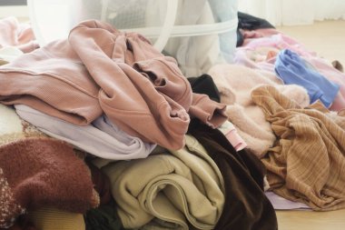 Düzensiz ama büyüleyici bir giysi yığını. Kapalı bir ortamda güzelce sergileniyor.