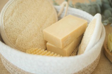 Tahta bir yüzey üzerinde sabun, vücut fırçası, lif ve okaliptüs içeren doğal spa seti..