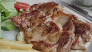 Kızarmış tavuk eti, patates kızartması ve tabakta taze salata. ,