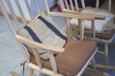 Bu güzel el yapımı sallanan sandalyede rahat etmeniz için eşsiz desenli yastıklar var.