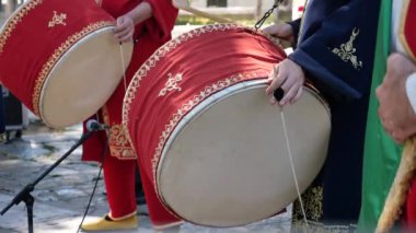 Kırmızı davullar, coşkulu bir kültürel kutlamada müzisyenler tarafından ustalıkla çalınır ve neşe getirir.