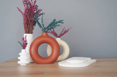 Şık dekorda canlı vazolar ve güzel düzenlenmiş kurumuş çiçekler var.