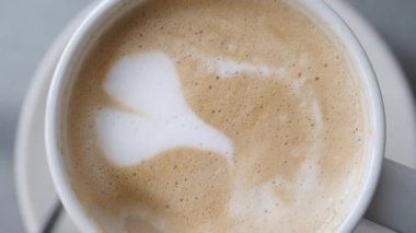 Beyaz şeker kahve fincanındaki kağıt bir paketten dökülüyor. .