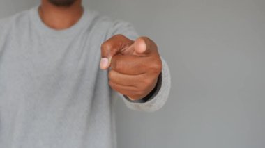 Tarafsız bir arkaplanı işaret eden bir elin yakınlaşması, nişanı vurguluyor