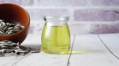 Ayçiçeği yağı tohumu ve yağ bir kabın içinde masanın üstünde ,