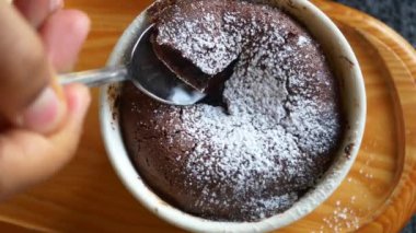 Çikolatalı lava kekinin tadını çıkar, üzerine pudra şekeri serp ve yanında krem şanti ile servis et.