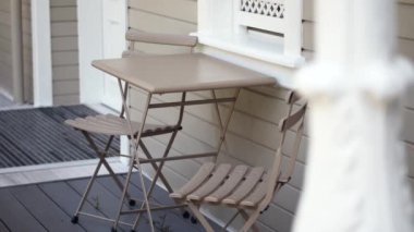 Verandada güzel, rahat sandalyeleri olan şık bir bar masası. Rahatlamak için ideal.