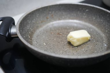 Tereyağı yavaşça kızartma tavasında eriyor. Lezzetli yemeklerin hazırlanmasını sabırsızlıkla bekliyor.