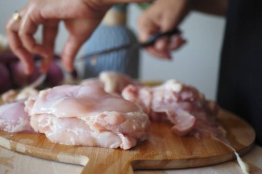 Tavuk filetosunu doğrama tahtasıyla kesiyorum. ,