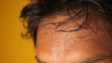 Alnındaki terin koyu arkaplana yakın çekimi 