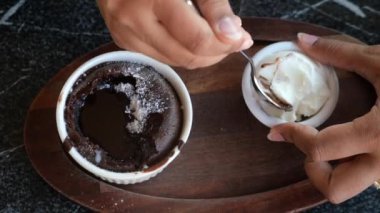 Çikolatalı lava kekinin tadını çıkar, üzerine pudra şekeri serp ve yanında krem şanti ile servis et.