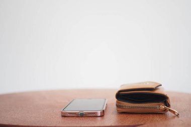 Bir akıllı telefon, tarafsız bir arkaplana karşı ahşap bir masanın üzerine yerleştirilir.