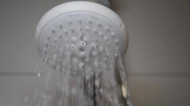 Şık, modern bir duş başlığı kristal berrak su dökerek ferahlatıcı bir banyo atmosferi yaratır.