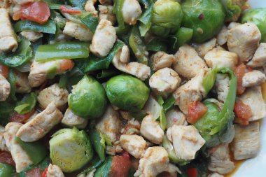 Brüksel lahanası ve renkli sebzelerle lezzetli bir tavuk kızartmasının tadını çıkar.