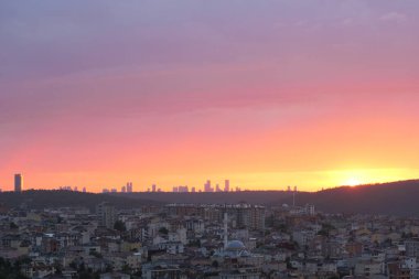 Nefes kesen bir günbatımı gökyüzünü şehrin ufuk çizgisine boyuyor, şehir güzelliğini gözler önüne seriyor..