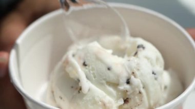 Çikolata parçacıkları ile süslenmiş lezzetli kremalı bir kepçe dondurma.