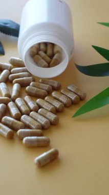 Bitkisel ilaç kapsülünün beyaza düşüşünün üst görüntüsü ,