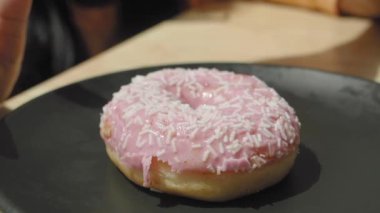 Bir çocuk kendi elleriyle çikolatalı donut seçiyor..