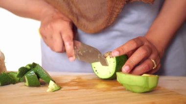 Kadın mutfak bıçağıyla avokado kesiyor. ,