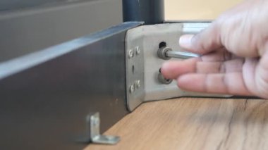 İngiliz anahtarı kullanarak, metalden vidayı çıkarıyorlar.,