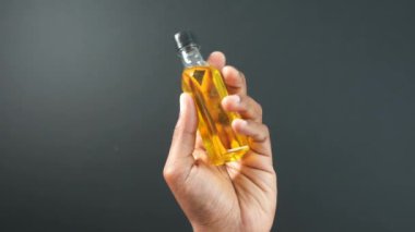 Bir şişe zeytinyağını tutan el. .